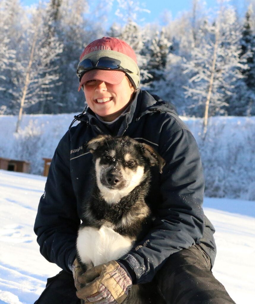 image of Maddox holding a dog in snowy landscape