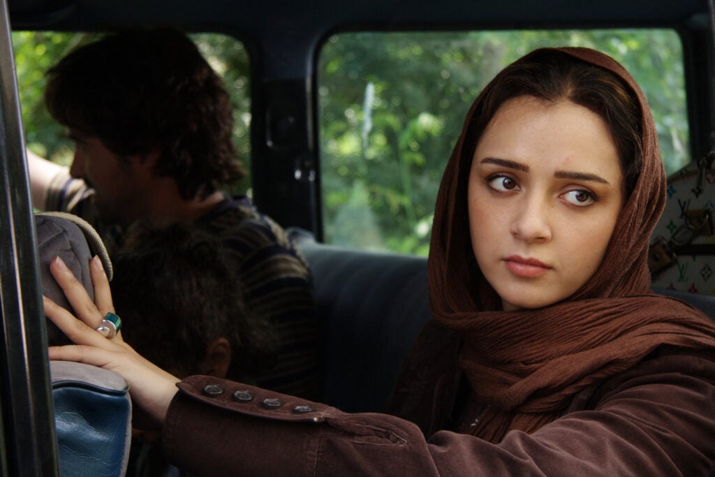 woman wearing head covering in the open window of a vehicle