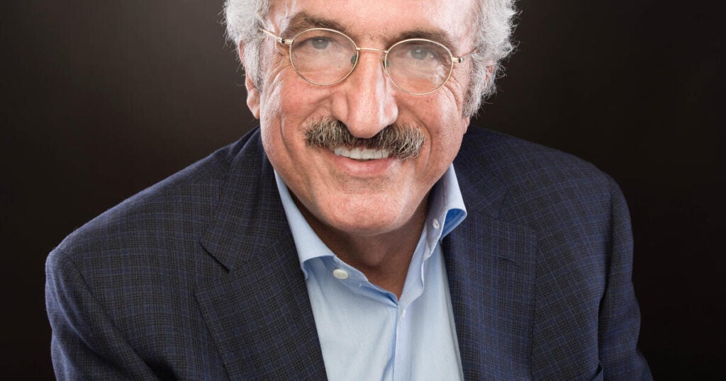 White man with white hair, gray mustache, and glasses